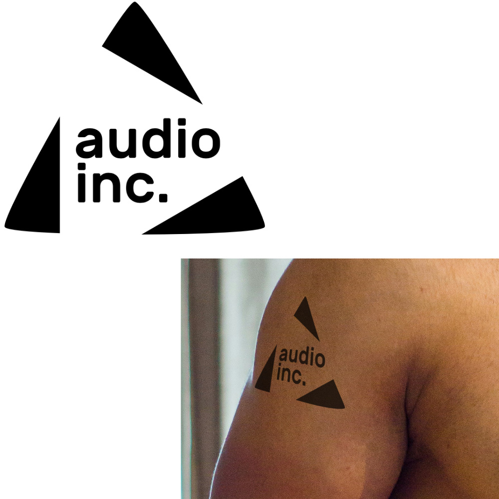 Triangular logo containing the words Audio Inc as a tattoo on the upper arm of a young man